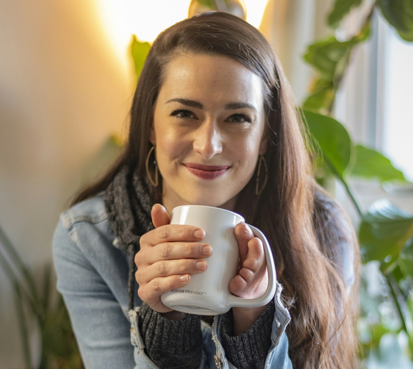 Smiling woman holding a coffee mug at home